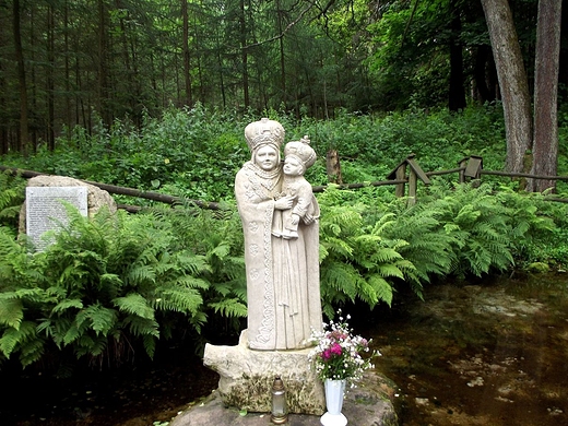 Kamienna figura Matki Boej przy kapliczce na wodzie