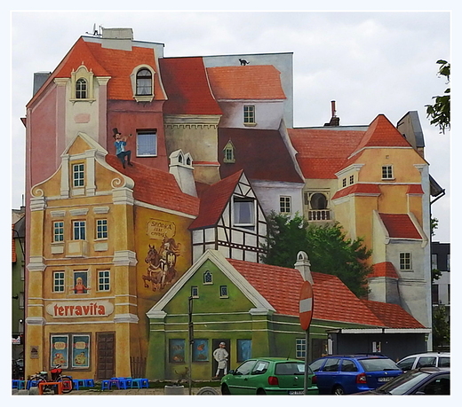 Trjwymiarowy mural Opowie rdecka z trbaczem na dachu i kotem w tle na rogu ulic rdka i Rynek rdecki