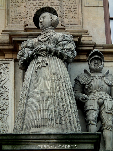 fragment detalu na budynku bramnym Zamku Piastw lskich w Brzegu przedstawiajcy kamienne posgi ony Jerzego II Barbary.