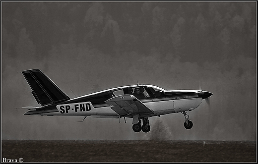 Socata TB-20 Trinidad w locie nad lotniskiem w Aleksandrowicach - B&W