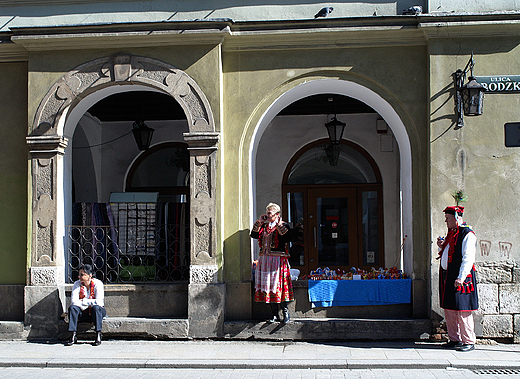 Krakw. Scenka uliczna. Sprzedawcy w strojach regionalnych.