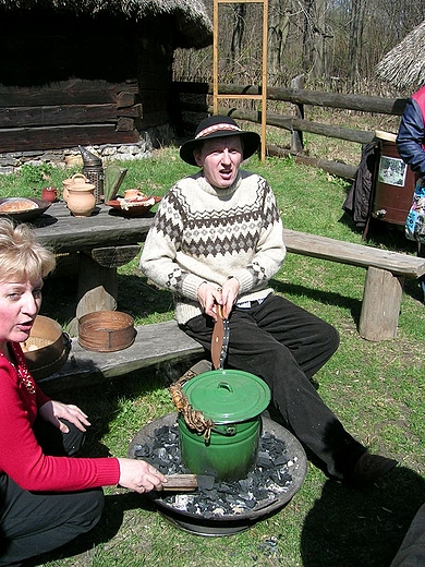 Pszczelarz gotuje jajka na poczstunek dla zwiedzajcych skansen