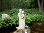Kamienna figura Matki Bożej przy kapliczce na wodzie